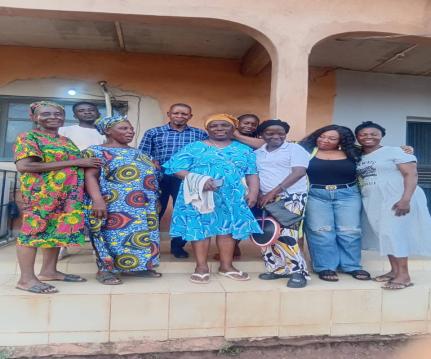 Community members in traditional and contemporary attire on a porch