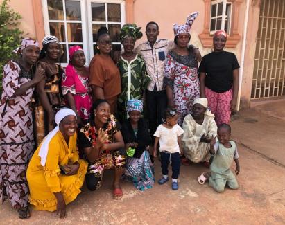 Multigenerational Liberian community members including children gathered outdoors
